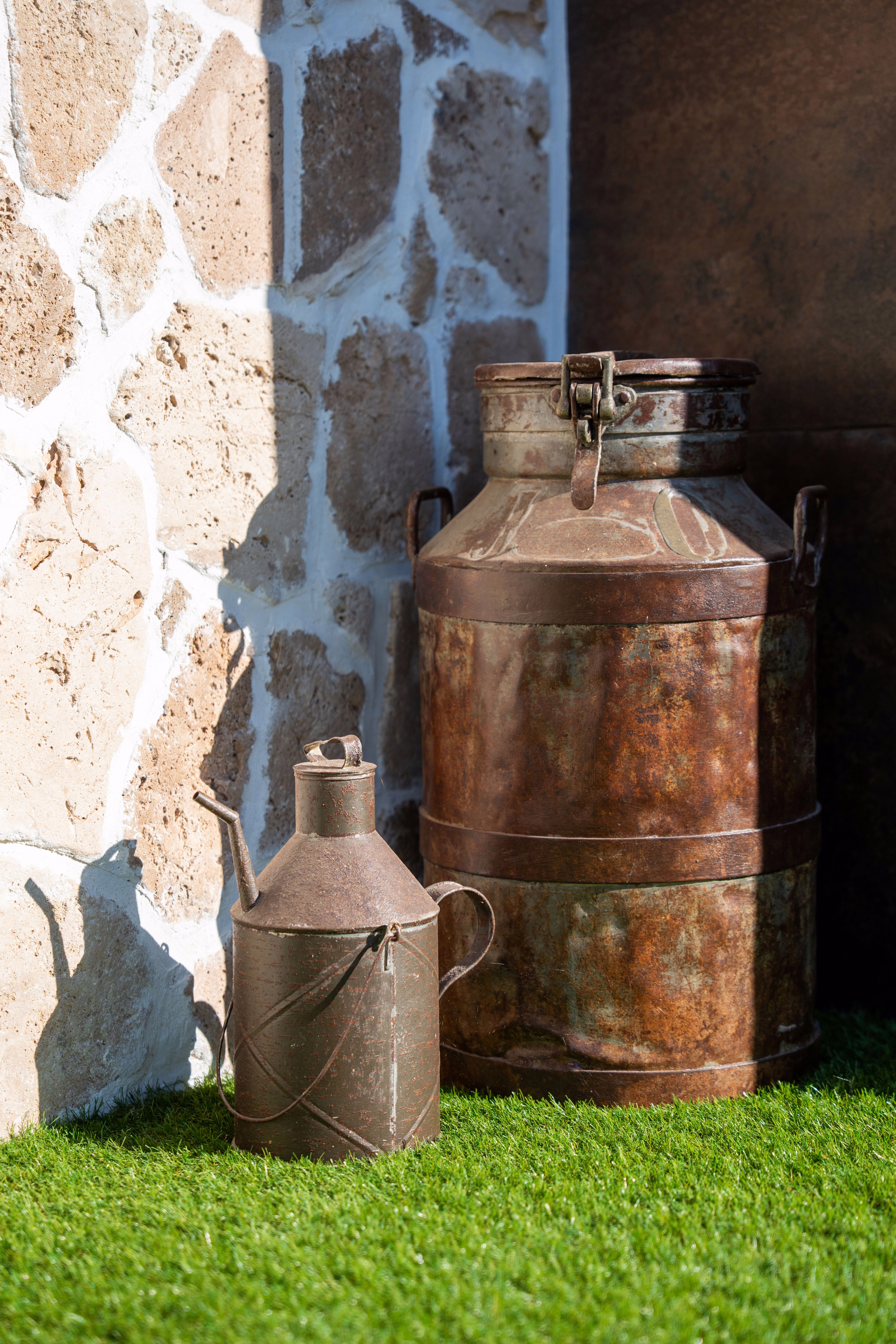 Detalle decorativo con bidón lechero y aceitero antiguos, toque auténtico y rural en los exteriores.
